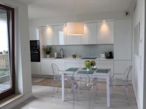 格丁尼亚Apartament Sea Towers View的白色的厨房配有白色的桌子和椅子