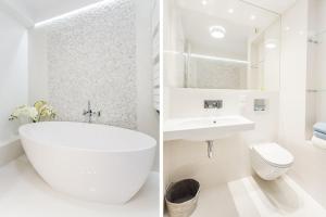 格丁尼亚Apartament Sea Towers View的白色的浴室设有浴缸、水槽和卫生间。