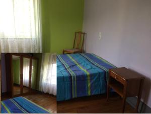 Sainte-SuzannePetite maison proche de Montbéliard的卧室两张照片,配有一张床和一把椅子