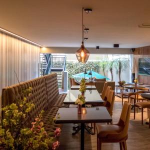 墨西哥城Dominion Polanco的一间带桌椅的餐厅和一个游泳池