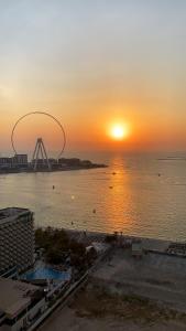 迪拜California Hostel Dubai Beach的水上的摩天轮日落