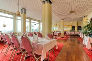 普特加登FF&E Hotel Dania的宴会厅配有桌椅和窗户