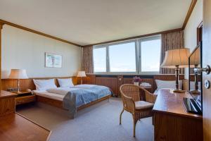 普特加登FF&E Hotel Dania的一间卧室配有一张床、一张桌子和一把椅子