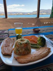 普诺Uros Titicaca Khantaniwa Lodge的一块食物,包括肉和蔬菜以及一杯橙汁