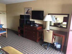 Storm Lake经济汽车旅馆的酒店客房配有一张桌子、一张床和一台电视