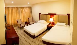 马尼拉Swiss-Belhotel Blulane的酒店客房配有两张床和一张书桌