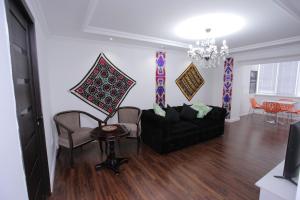 撒马尔罕Overlooking Registan Square Luxury 2 Bedrooms Apartment的客厅配有黑色沙发和椅子