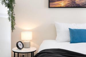 布里斯班Amazing River View - 3 Bedroom Apartment - Brisbane CBD - Netflix - Fast Wifi - Carpark的一间卧室配有一张床和一张桌子上的闹钟