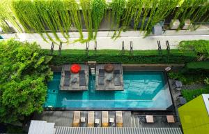 曼谷LiT BANGKOK Residence的享有带椅子和红花的游泳池的顶部景致