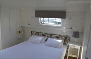 里斯本Tagus Marina的卧室配有白色的床和窗户。