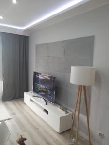 格但斯克Apartament Nowa Letnica的一间客厅,客厅的白色橱柜上配有电视