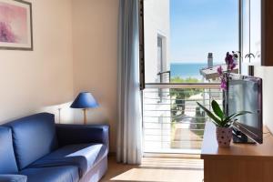 利尼亚诺萨比亚多罗伊丝贝丽雅公寓酒店的客厅设有蓝色的沙发和大窗户