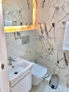 伦敦Widegate Residential的白色的浴室设有水槽和卫生间。