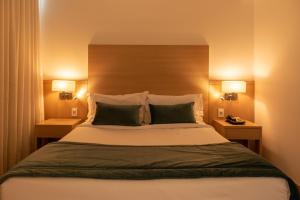 里约热内卢美洲巴拉酒店 的一间卧室配有一张大床和两盏灯