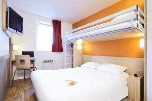 伊格涅南里昂 - 圣皮埃尔普瑞米尔经典酒店的一间酒店客房,配有白色的床和电视