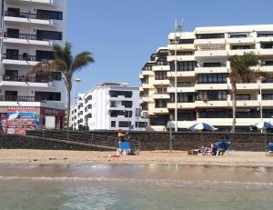 阿雷西费Cómoda ubicación, cerca de la playa的一群人在海滩上建有建筑物
