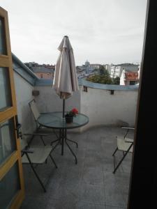 康斯坦察Garsoniera langa plaja的阳台配有桌椅和遮阳伞