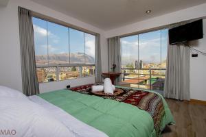 库斯科Latinos House Cusco的一间卧室设有一张大床和一个大窗户