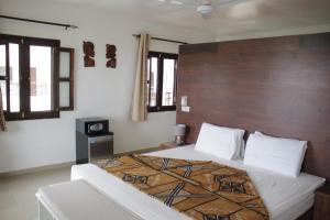 班珠尔Harmony Resort Boutique Hotel的一间卧室配有一张大床和木制床头板