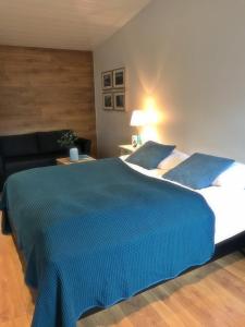 塞尔福斯梭里斯同公寓的一间卧室配有一张带蓝色毯子的大床
