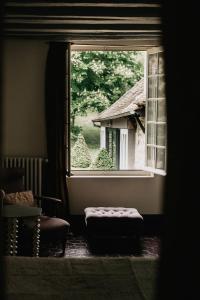 吉维尼乐达米蒂基韦尔尼住宿加早餐旅馆的一个带椅子和凳子的房间的窗户