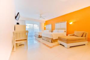 坎昆Occidental Costa Cancún - All Inclusive的酒店客房,配有两张床和椅子