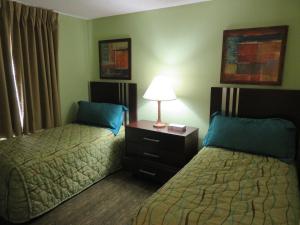 帕诺滩分时冲浪者度假酒店的酒店客房,设有两张床和一盏灯