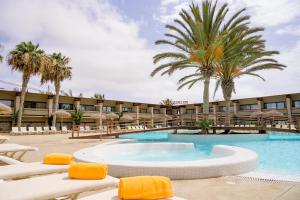 圣玛丽亚奥西斯贝洛伊宗提度假酒店的一个带椅子和棕榈树的度假村游泳池