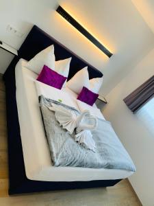 斯拉德明ImPuls | aparts的一间卧室配有一张带紫色和白色枕头的床