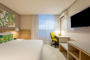 基布多Mia Hotel Choco的酒店客房配有一张床、一张书桌和一台电视。