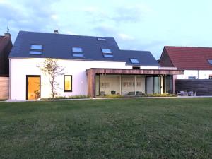 Beauvechainma-tinée的一间白色的房子,有黑色的屋顶和院子