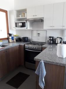 维加伊托PARADISE EN VICHAYITO的厨房配有白色橱柜和炉灶烤箱。