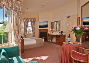 肯图巴Mountain Heritage Hotel的配有一张床和一张书桌的酒店客房