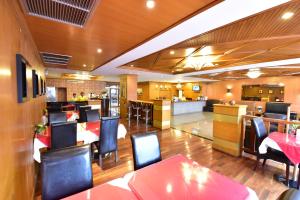 芭堤雅市中心芭堤雅王朝酒店 的一间带桌椅的餐厅和一间酒吧
