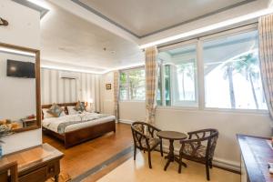 长滩岛Royal Park Resort Boracay的卧室配有一张床和一张桌子及椅子