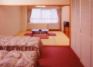 汤泽町汤泽银水木屋酒店的一间卧室配有一张床、一张桌子和一个窗户。
