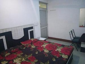 帕坦科特Sai Guest House的一间卧室,床上有红色玫瑰