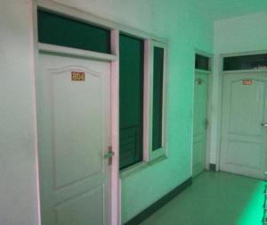 帕坦科特Sai Guest House的一间设有两扇白色门和绿色墙壁的客房