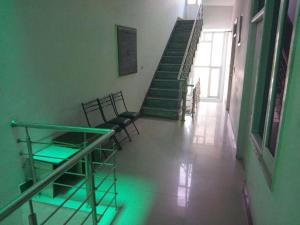 帕坦科特Sai Guest House的走廊上设有椅子和绿灯楼梯