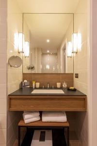 科涅克Appartements Chais Monnet的一间带水槽和大镜子的浴室
