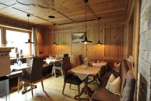 伊施格尔Hotel Verwall的餐厅拥有木墙和桌椅
