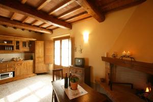皮恩扎圣格雷戈里奥波德雷农庄酒店的厨房配有木桌和壁炉。