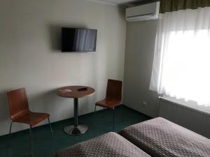 派尔努赫玛库宾馆的配有一张床、一张桌子和两把椅子的房间