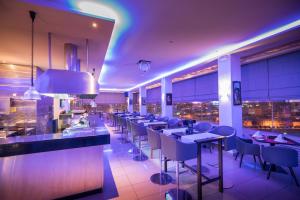 苏塞Sousse Palace Hotel & Spa的餐厅设有配备了桌椅的长酒吧