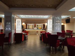 KhorogPamir Palace的一间设有红色桌椅的餐厅和一间酒吧