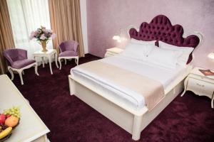 曼加利亚Royal Boutique Mangalia Breeze的一间卧室配有一张大床和红色床头板