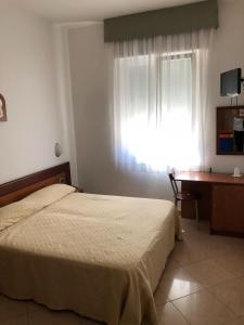 普拉亚·阿马勒雷克斯酒店的一间卧室配有一张床、一张书桌和一个窗户。