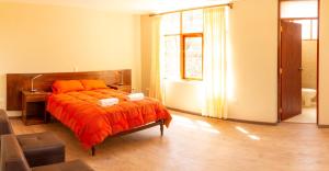 乌鲁班巴Allin Illary Eco Hospedaje的一间卧室配有一张带橙色毯子的床