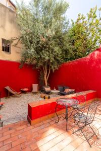 马赛LE PANIER ENCHANTÉ - Suites & Loft - Terrasse et patio au dessus du Vieux Port的红长凳和桌子,树