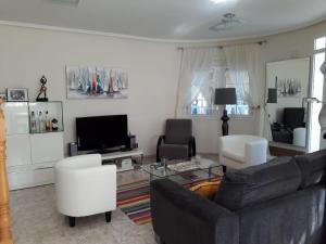 罗哈莱斯casa ronda的客厅配有沙发、椅子和电视